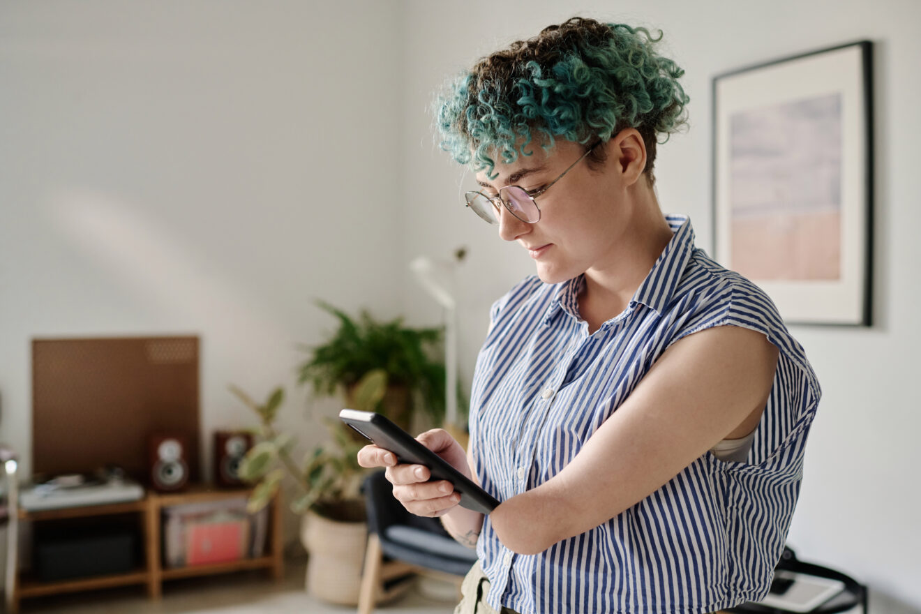 Junge Frau mit Invalidität nutzt ihr Smartphone.  